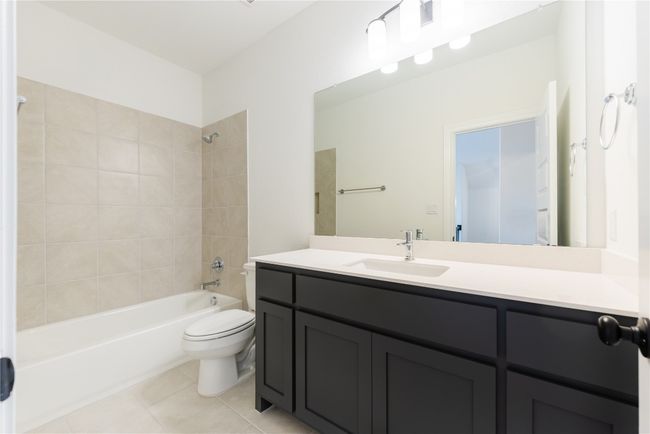 Full bathroom with shower combination, vanity, and tile patterned flooring | Image 12