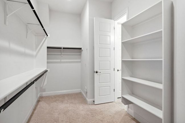 The generous walk-in closet offers hanging and shelving storage, and it also features entry to the laundry room! | Image 25