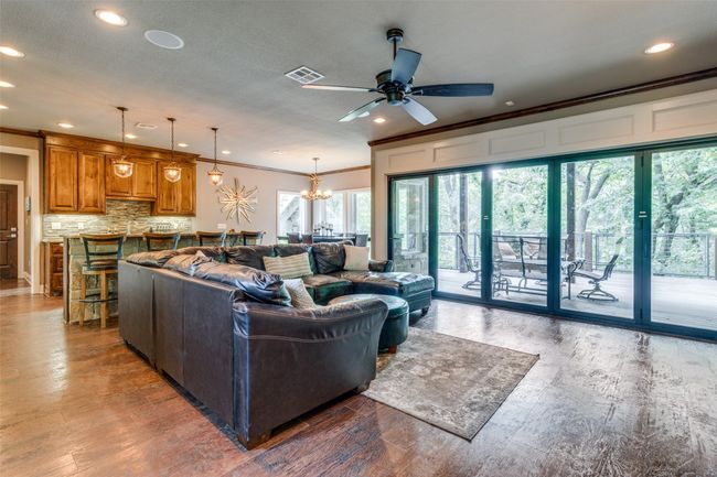 Living room with ornamental molding, ceiling fan with notable chandelier, and hardwood / wood-style flooring | Image 5