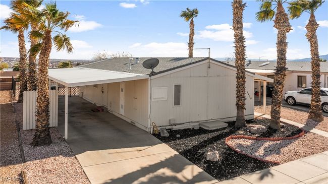 View of front of home with a carport, driveway, and a shingled roof | Image 62