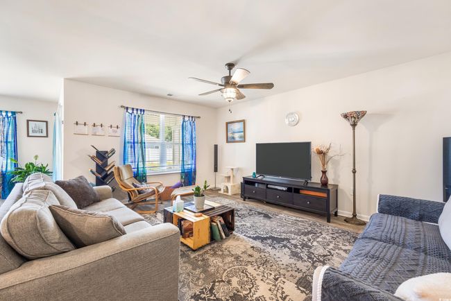 Living room with ceiling fan, wood finished floors, and baseboards | Image 22
