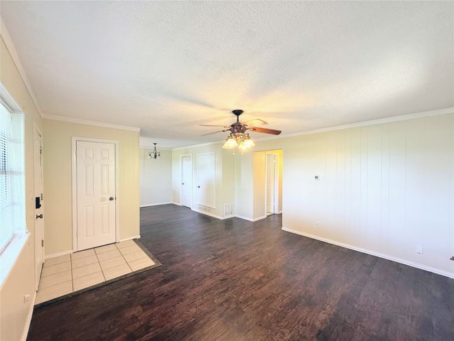 Unfurnished room with wood finished floors, a ceiling fan, a textured ceiling, and ornamental molding | Image 4