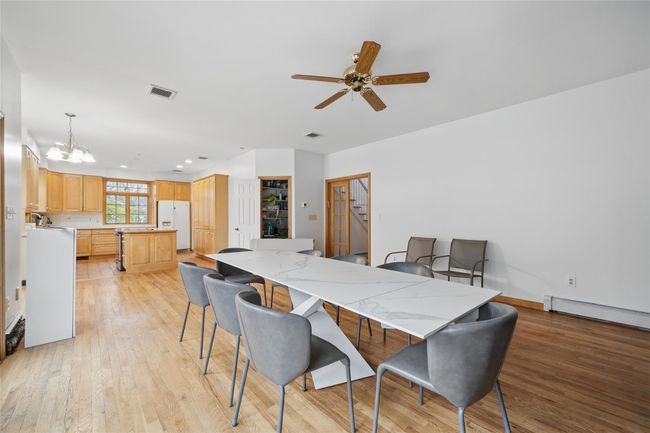 Dining area with light wood finished floors, visible vents, recessed lighting, and ceiling fan with notable chandelier | Image 8