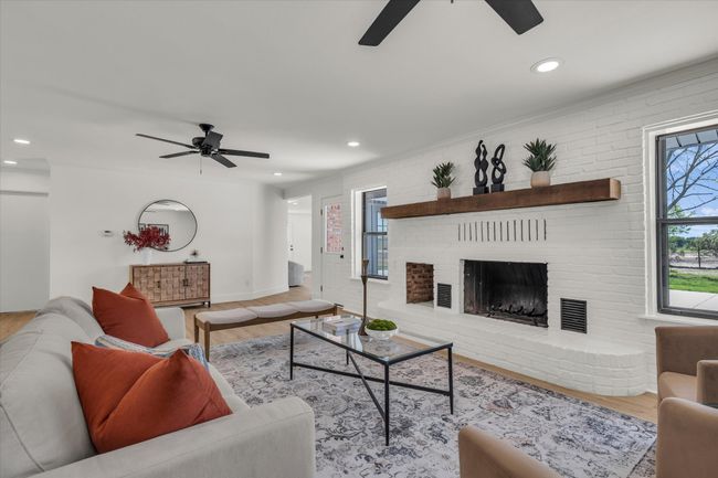 Living area featuring recessed lighting, a ceiling fan, wood finished floors, and a fireplace | Image 16