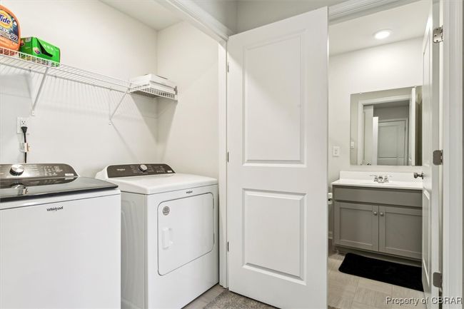 Laundry room with washing machine and clothes dryer, a sink, and laundry area | Image 26