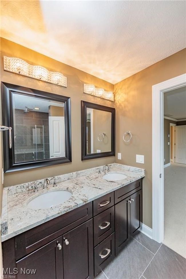 Bathroom with tile patterned flooring, double vanity, a sink, and walk in shower | Image 8
