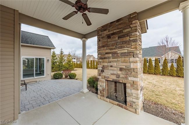 View of patio / terrace with ceiling fan and an outdoor stone fireplace | Image 17