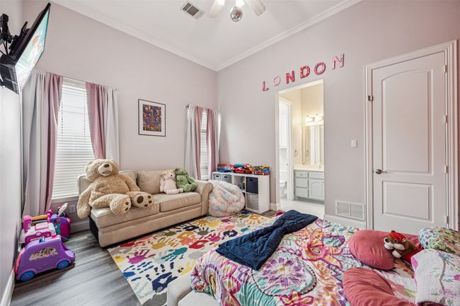 Bedroom featuring crown molding, ensuite bath, wood finished floors, and ceiling fan | Image 16