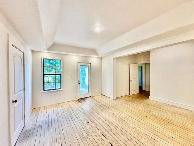 Spare room featuring a raised ceiling and light wood-style flooring | Image 11