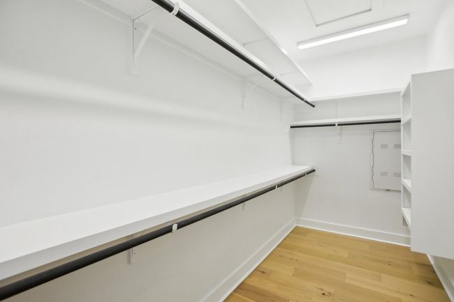 Spacious closet with light wood-type flooring | Image 34