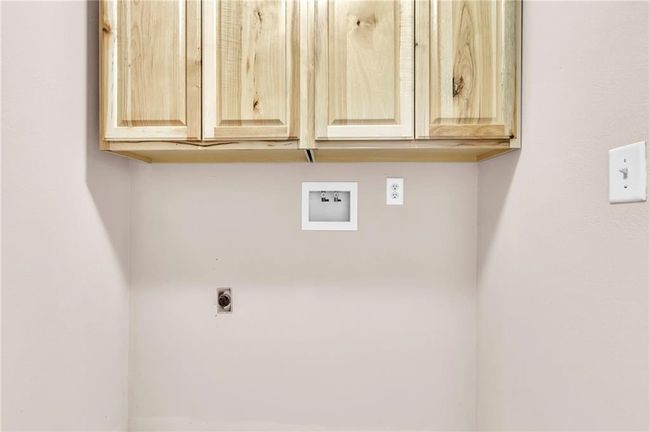 Clothes washing area featuring hookup for an electric dryer, washer hookup, and cabinet space | Image 27