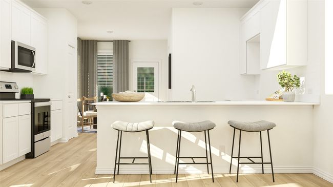 Kitchen featuring appliances with stainless steel finishes, light wood-type flooring, and white cabinetry | Image 9