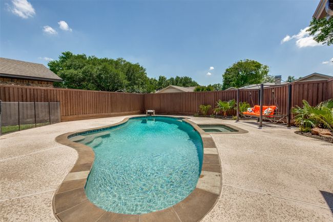 View of swimming pool with a patio, a fenced backyard, and an in-ground hot tub | Image 34
