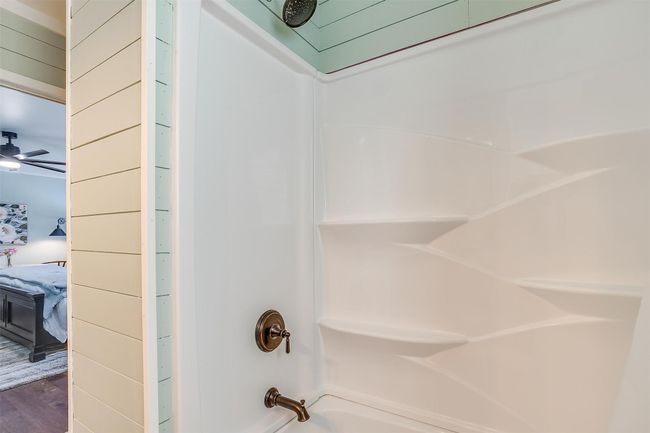 Bathroom featuring connected bathroom, wood finished floors, and washtub / shower combination | Image 30
