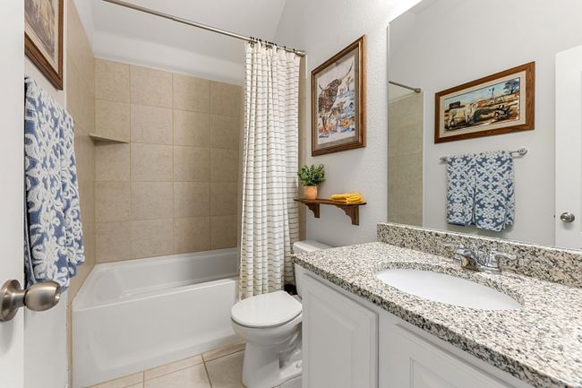 Full bathroom with shower / tub combo, tile patterned floors, vanity, and toilet | Image 22