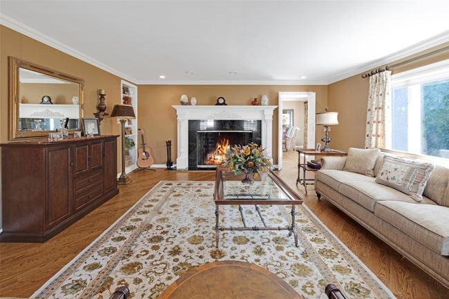 Living room featuring ornamental molding, a premium fireplace, and wood finished floors | Image 4