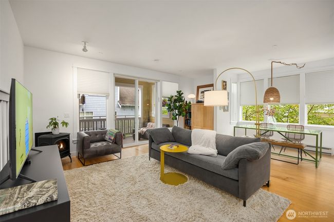 Tall ceilings and windows allow for plenty of natural light. View to the living room, dining room, built-in maple cabinet and slider to the covered balcony. | Image 4