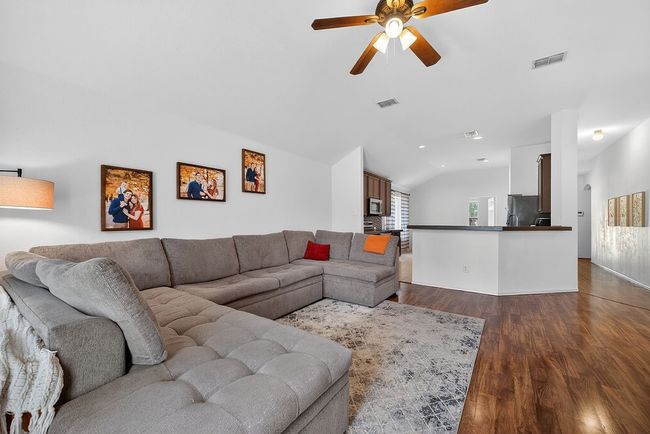 Living room featuring vaulted ceiling, ceiling fan, and dark wood finished floors | Image 30