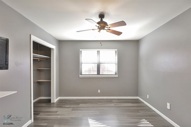 Unfurnished bedroom with ceiling fan, dark hardwood / wood-style flooring, and a closet | Image 15