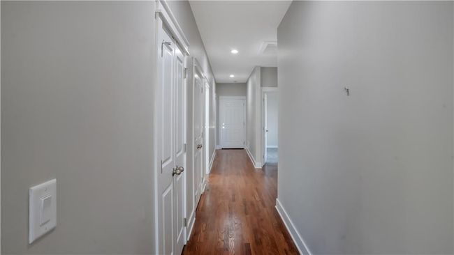 Hallway featuring dark wood-style floors, baseboards, and recessed lighting | Image 21