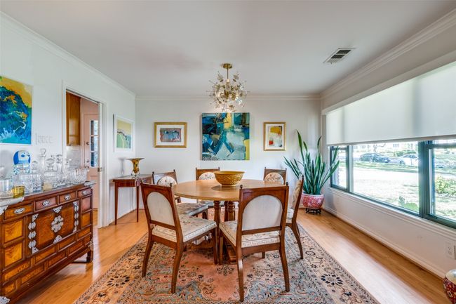 Dining space with crown molding, a notable chandelier, and light wood-type flooring | Image 9
