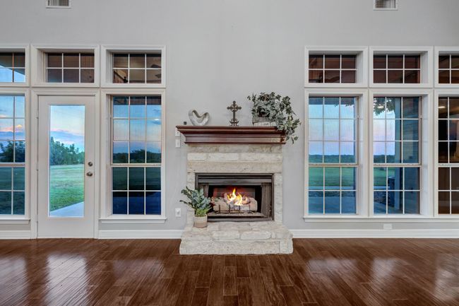 Inviting, Austin stone fireplace flanked by elegant wall of windows and transome accent windows | Image 15