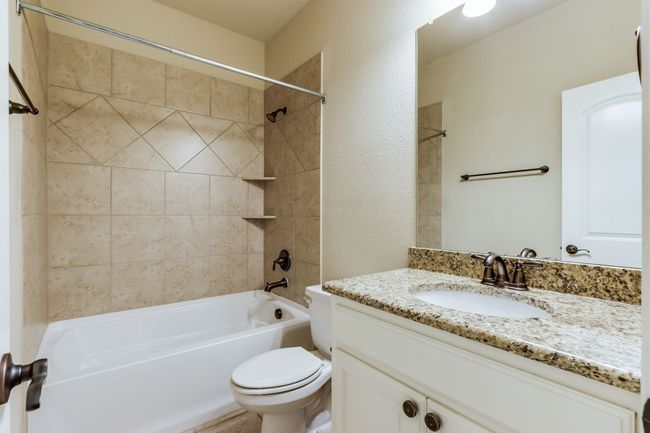 Full bath featuring vanity, shower / bath combination, and a textured wall | Image 26