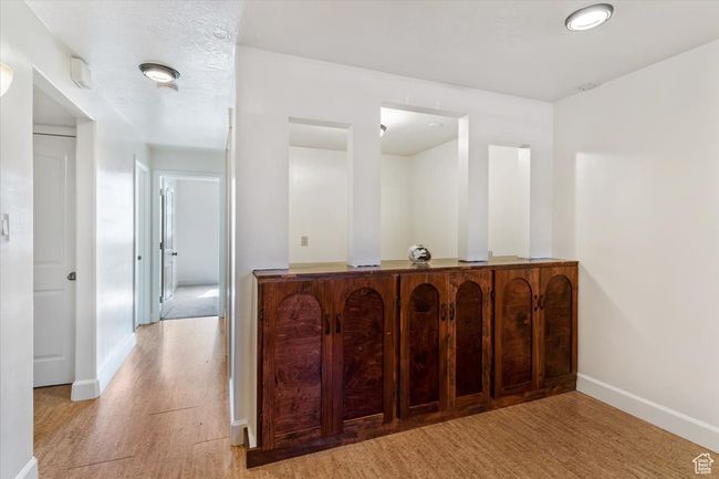 Bar featuring baseboards and light wood-style floors | Image 23