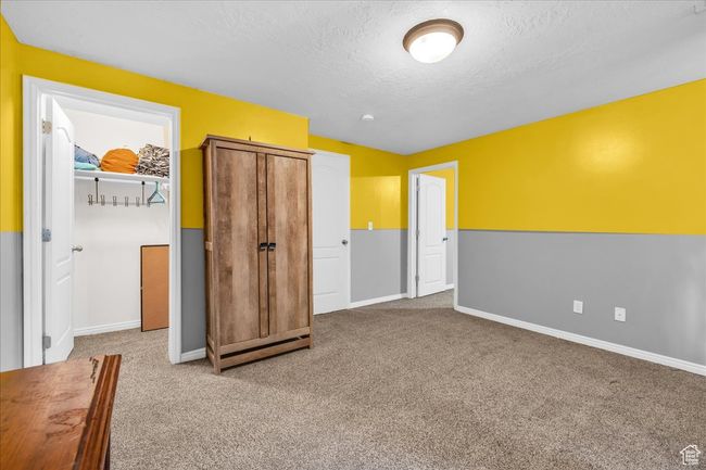 Unfurnished bedroom with a textured ceiling, baseboards, and carpet floors | Image 9