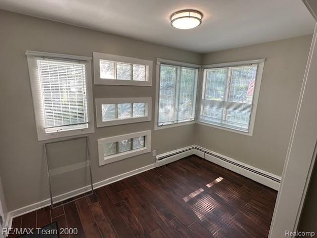 Spare room with dark wood-style flooring and baseboard heating | Image 7