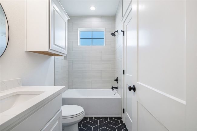 Full bathroom featuring vanity, tiled shower / bath combo, toilet, and tile patterned flooring | Image 23