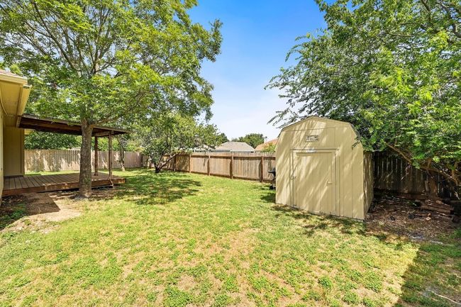 Fenced backyard with a storage shed and a wooden deck | Image 31