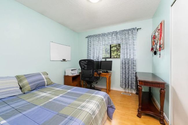 Bedroom featuring baseboards, wood finished floors, visible vents, and a textured ceiling | Image 14