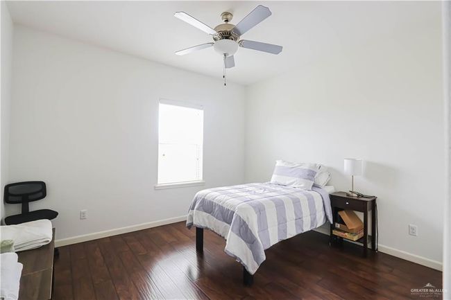 Bedroom with hardwood / wood-style floors, a ceiling fan, and baseboards | Image 15