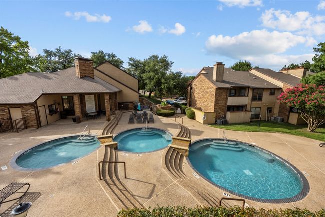 View of swimming pool with a pool with connected hot tub and a patio area | Image 32