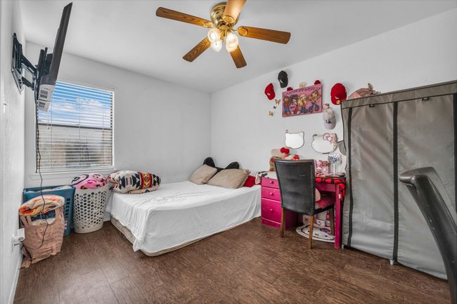 Bedroom with wood finished floors and ceiling fan | Image 9
