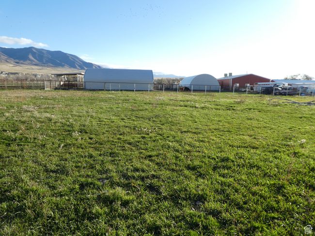 View of yard featuring a pole building, a mountain view, an outbuilding, and a rural view | Image 11