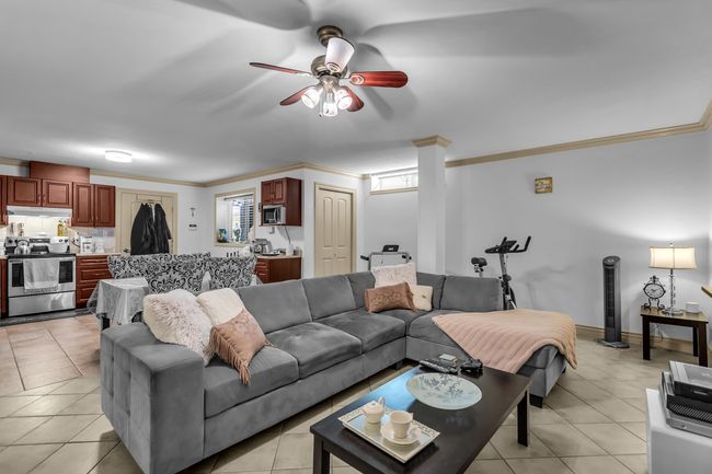 Living room featuring a ceiling fan, light tile patterned floors, and ornamental molding | Image 25