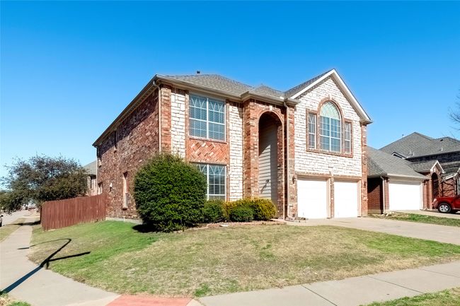 Traditional home featuring brick siding, concrete driveway, an attached garage, a front yard, and fence | Image 39