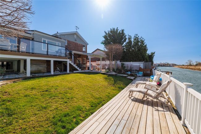 View of yard with stairs, fence, and a deck with water view | Image 29