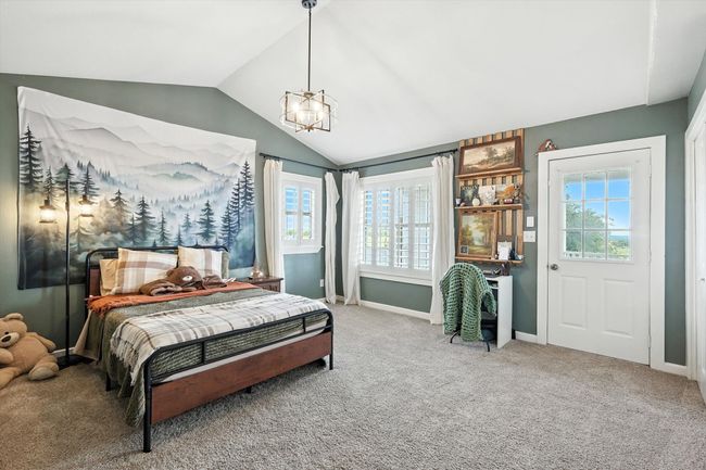 Carpeted bedroom with lofted ceiling and multiple windows | Image 29