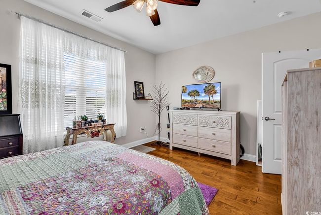 Bedroom featuring a closet, wood finished floors, baseboards, and ceiling fan | Image 7
