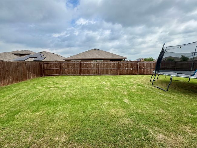 View of yard with a trampoline | Image 15