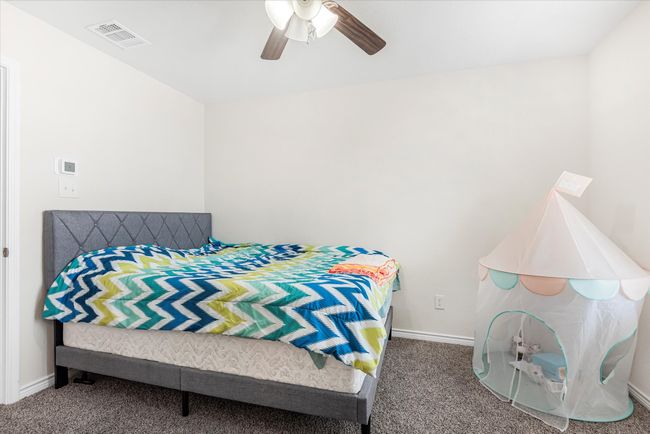 Carpeted bedroom with visible vents, ceiling fan, and baseboards | Image 20