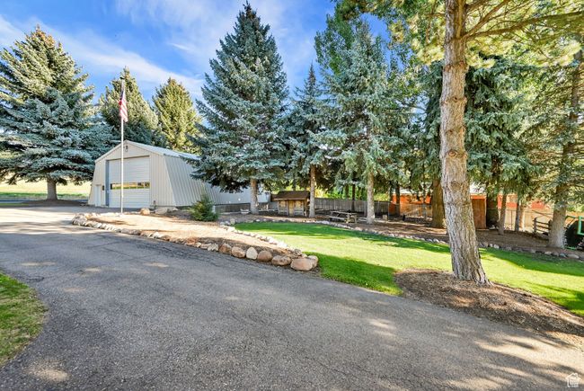 View of front of home featuring a front yard, a garage, and an outdoor structure | Image 35
