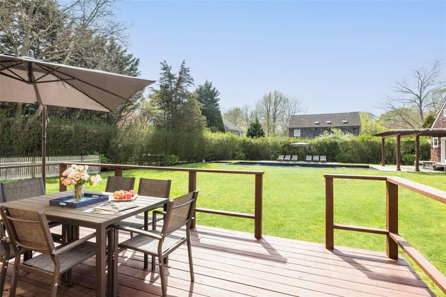 Wooden deck with a yard, outdoor dining space, and fence | Image 6