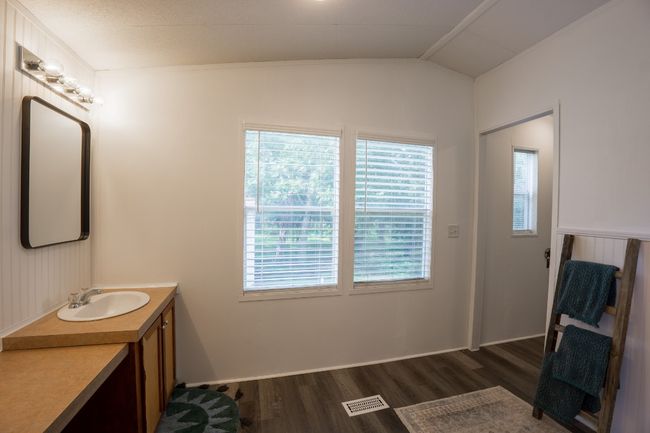 Bathroom with wood finished floors, vanity, plenty of natural light, and lofted ceiling | Image 28