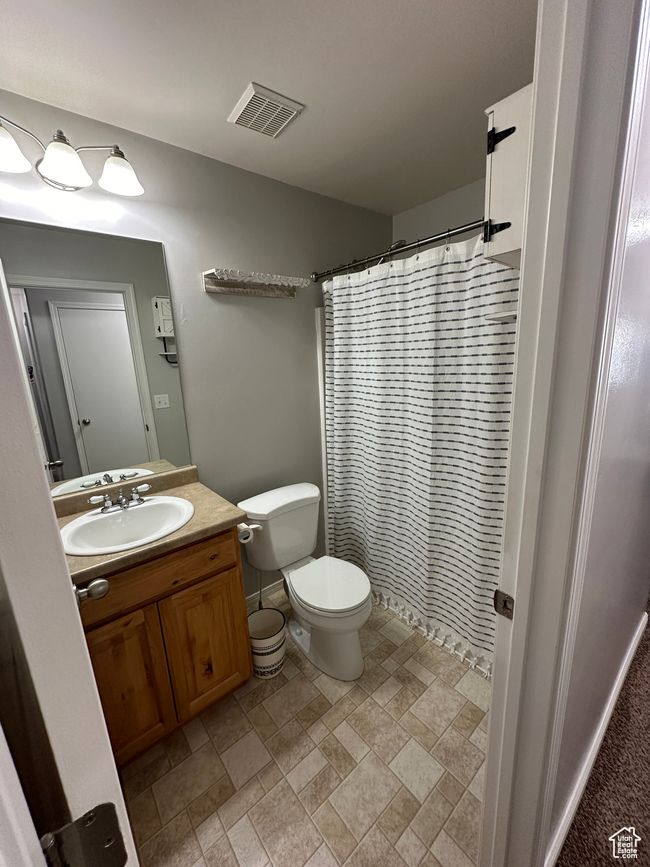 Full bath featuring stone finish floor, visible vents, toilet, vanity, and a shower with curtain | Image 18