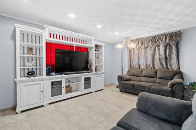 Living room featuring crown molding and tile patterned floors | Image 3