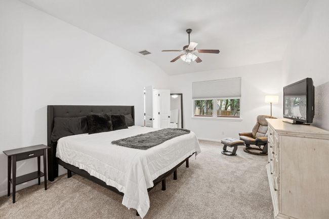 Bedroom with light carpet, vaulted ceiling, and a ceiling fan | Image 23